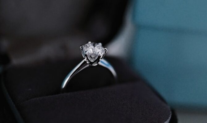 A luxury 1 carat princess cut diamond engagement ring showcased in a black velvet jewelry box.