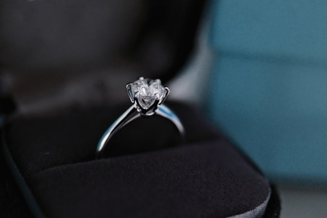 A luxury 1 carat princess cut diamond engagement ring showcased in a black velvet jewelry box.